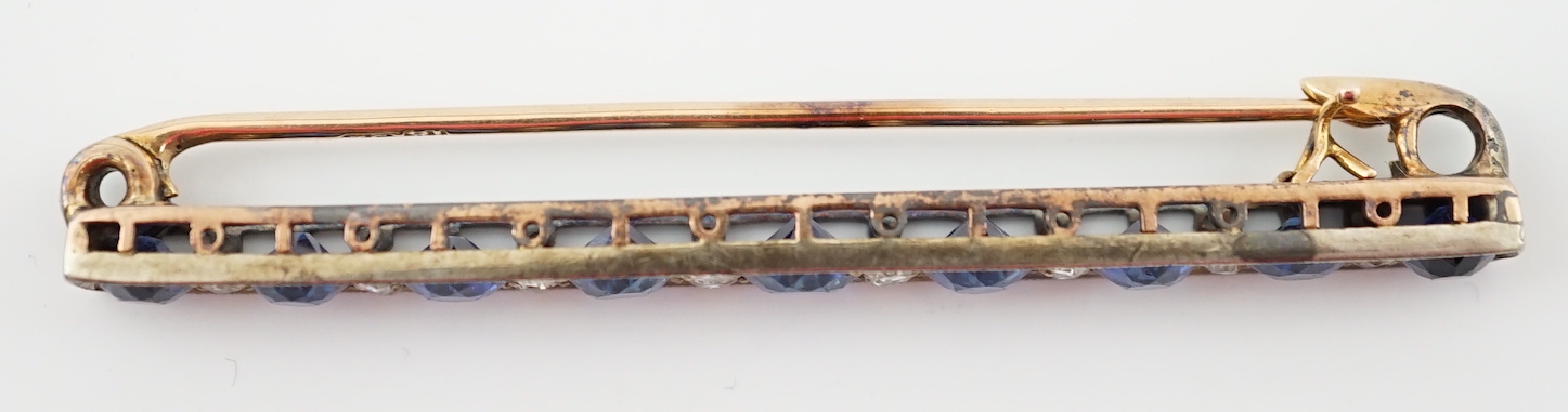 An Edwardian gold and graduated nine stone round cut sapphire set bar brooch